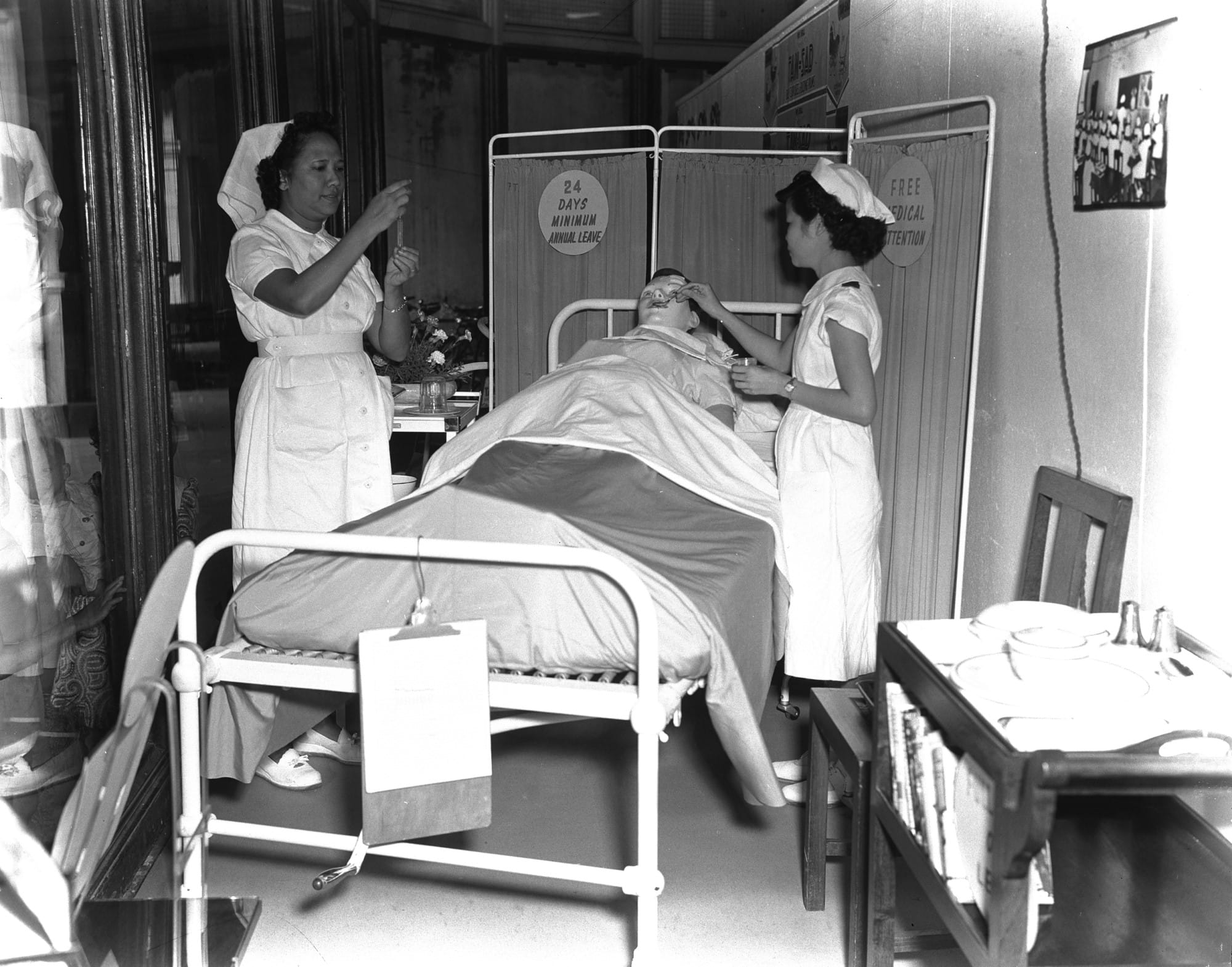 Nurses at a John Little shop window tending to a dummy patient as part of a 1952 recruitment campaign. Ministry of Information and the Arts Collection, courtesy of National Archives of Singapore.